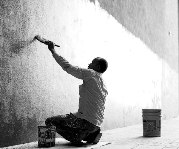 A painter rolling paint onto an interior wall